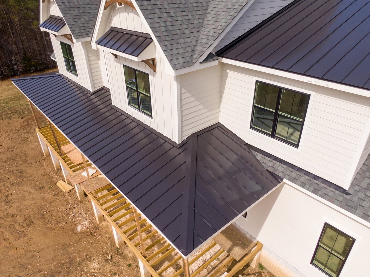 Home with newly installed asphalt shingle and standing seam metal roofing
