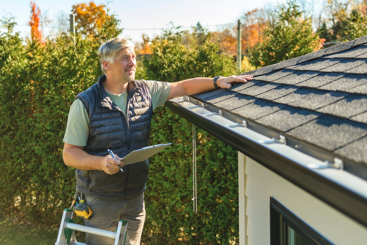 Roofing professional inspecting a residential roof